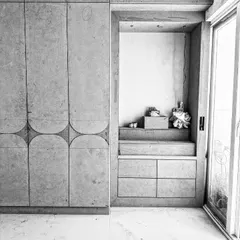 A black and white photo of a work-in-progress bedroom, showing a custom wardrobe with curved groove details next to a built-in mandir space. This image captures the raw structure and craftsmanship before the final finishes are applied.