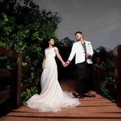For a classic and elegant look, I offer simple white gowns paired with stylish blazers for men. This coordinated outfit is perfect for a romantic shoot on a rustic wooden bridge.
