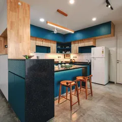 The T7 T8 kitchen with its vibrant blue cabinetry and rubberwood accents. The central island doubles as a breakfast counter, perfect for casual meals.