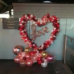 A perfect photo spot for any event celebrating love. This large, heart-shaped balloon frame is filled with a "Love" foil balloon, creating a beautiful and interactive decoration for guests.