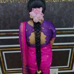A variation of the traditional braid, this time decorated with a single, beautiful lotus flower. This simple addition adds a unique and divine touch to the hairstyle.