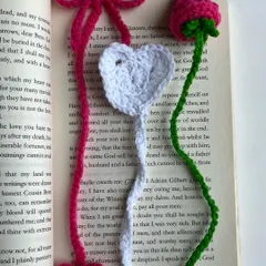 This image showcases two different bookmark styles. On the left is a white heart bookmark with a pink bow, and on the right is a pink rose bookmark with a green stem.