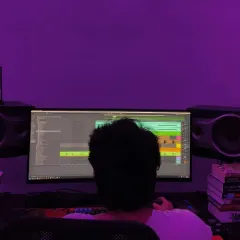 A behind-the-scenes look at me working on a track in my studio. The purple lighting helps set the mood for a creative session.