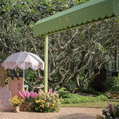 The welcome entrance to the brunch, with a scalloped green awning and a cute sign, surrounded by baskets of fresh, colorful flowers.