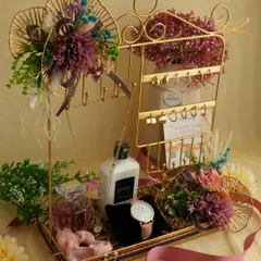A gift designed for someone who loves to accessorize. This hamper features a jewelry stand, perfume, lotion, a watch, and other personal items, all elegantly arranged in a decorative tray.