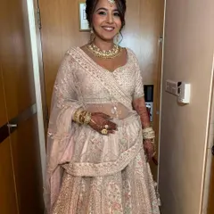 A full-length shot of the bride in her elegant pastel lehenga. The makeup is understated and sophisticated, perfect for her minimalist style.