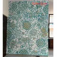 This accent wall showcases a vibrant Calcecruda texture combined with a bold mandala stencil design. The teal, white, and gold color combination creates a striking and artistic statement piece for any room.