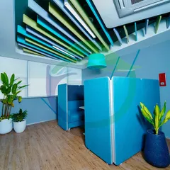 A before-and-after edit showing how a simple change in color palette can affect the mood. Here, we placed tall plants in white planters to soften a corner with blue privacy booths, adding a natural touch to the modern office furniture.