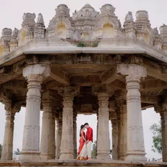 Framed by the magnificent stone pillars of a heritage temple in Melukote, a couple shares an intimate moment, their vibrant red outfits a beautiful contrast to the ancient stone. This shot showcases my love for blending romance with history.