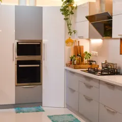 A view of my modern kitchen, showing the built-in oven unit and the sleek, handleless cabinets in a two-tone grey and white finish.