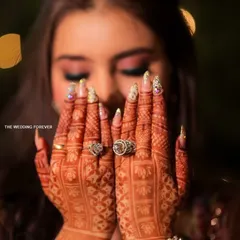 Mehendi night glam. These nails, adorned with glitter and stones, were designed to shine alongside the beautiful henna art, adding an extra layer of sparkle to the pre-wedding celebrations.