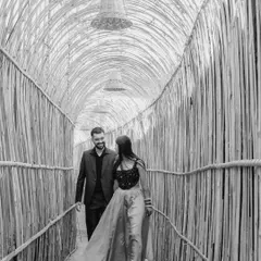 A walk through a bamboo tunnel becomes a cinematic moment. This black and white photograph captures the couple in motion, creating a sense of a shared journey.