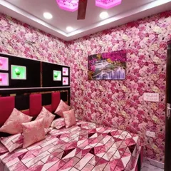 This bedroom is covered in a dense floral rose pattern, creating a vibrant and romantic atmosphere. The pink theme is continued in the bedding and headboard for a complete look.