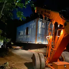 Another container being maneuvered by a crane at night. My container projects often involve complex logistics to assemble the basic building blocks.