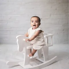 Sometimes, the simplest moments are the most precious. For this classic baby portrait, I used a clean, white backdrop and a simple rocking horse to keep the focus entirely on the baby's bright, happy expression. It’s a pure and timeless way to remember this sweet stage.