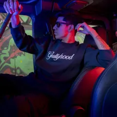 This image uses the interior of a vehicle and dramatic red and blue lighting to create a moody, cinematic feel. It's a creative approach to a streetwear lookbook that captures a specific nighttime vibe.
