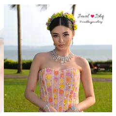A full view of our modern Mehendi look. The bride wears a delicate yellow diamond necklace that adds a touch of sunshine to her colourful floral outfit, perfect for an outdoor destination wedding.