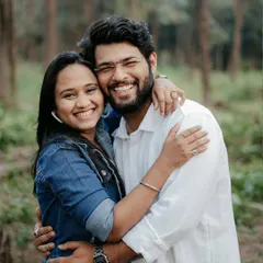 A bright, happy photo of a couple in a forest setting, hugging and smiling directly at the camera. Their genuine joy is infectious and shows the fun we have on our shoots.
