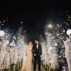 A spectacular sangeet night entrance. The couple walks down an aisle flanked by friends and dazzling cold-pyro sparklers, capturing the high energy and magical atmosphere of the celebration.