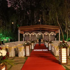 The approach to the stage is just as important as the stage itself. Here, a red carpet aisle is flanked by illuminated pedestals with floral arrangements, guiding guests' attention and creating a formal path for speakers or awardees.