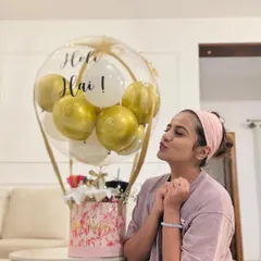 Actress Namratha Gowda enjoying her "Holi Hai!" balloon hamper. This festive gift features a decorative box base and a large clear balloon with a custom message.