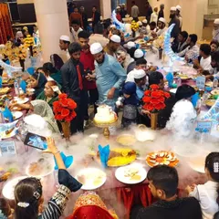 An overhead view of the celebration. Guests capture the moment as the dry ice smoke cascades over the table, creating a magical, cloud-like effect.