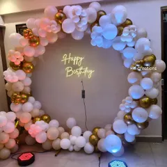 A chic and modern birthday setup perfect for any age. This decoration features a full circle of white and gold balloons with a "Happy Birthday" neon sign at the center.