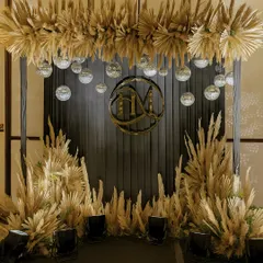 A chic and glamorous photo booth for a Sangeet night. This setup combines a custom gold monogram, sparkling disco balls, and dramatic pampas grass for a look that is both trendy and timeless.