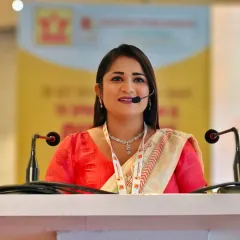 A close-up shot from the Deepak Publishers event. As a host, clear communication and a warm, professional expression are key to connecting with the audience during formal presentations.