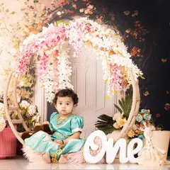 A beautiful first birthday portrait for Riya. This setup features a lovely floral hoop and soft lighting, creating a sweet and timeless image to mark her special milestone.