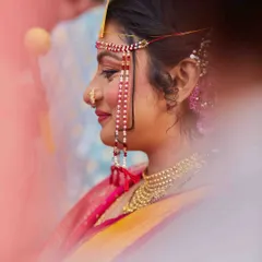 I used a soft focus and foreground blur to create this artistic and dreamy portrait of the bride. It highlights her traditional nose ring and serene profile.