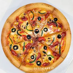 Would you prefer a slice of pizza or a slice of cake? This realistic-looking pizza is actually a chocolate truffle cake. I used cream and minimal fondant to create all the toppings, and it was decorated in just 20 minutes.