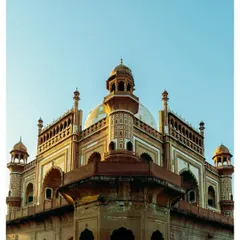 An angular view of Safdarjung's Tomb at golden hour, the warm light highlighting the intricate details of its domes and arches.