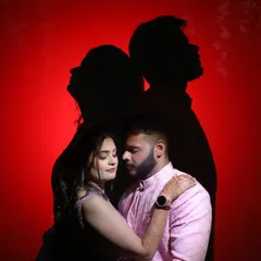 A creative couple portrait using their own shadows against a red background. This is a unique way to capture a couple's connection.