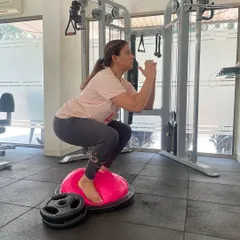 Working on balance and leg strength with squats on a BOSU ball. This advanced variation challenges stability and engages more muscles than a standard squat.