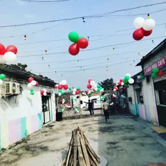 This outdoor area at a cafe was decorated with red, white, and green balloon bunches strung overhead to create a festive atmosphere for the Christmas season.