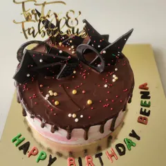 A "Forty & Fabulous" milestone birthday cake. This is my classic chocolate cake with a rich ganache drip, topped with abstract chocolate shards and colourful lettering for a fun, celebratory feel.
