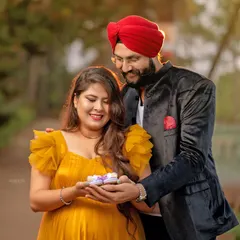 An outdoor couple's portrait with a sweet, interactive element. Sharing these little cupcakes adds a playful and personal touch to their maternity session in the park.