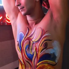 A stunning example of abstract body art created during one of my workshops. The chest becomes a canvas for fiery, expressive strokes of color, showing how painting can be a powerful form of personal storytelling.