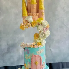 A dreamy, floating castle cake made with white chocolate cream, featuring a cascade of handmade sugar flowers.