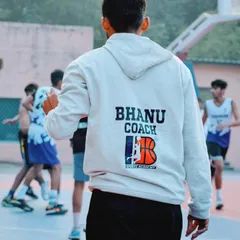 Coach Bhanu, seen here from the back, keeps a watchful eye on players during a tournament. Our coaches are always on the sidelines, providing guidance and support when it matters most.