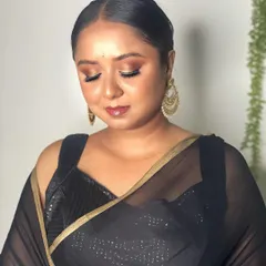 A classic party look featuring a black saree. I created a bronze smokey eye with a glossy lip and styled the hair in a sleek, elegant bun.