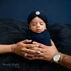 A tiny prince held safely in his parents' hands. This iconic newborn portrait captures the overwhelming love and protection that surrounds a new baby. It's a simple, powerful image that families will treasure forever.