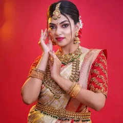 A beautiful bride adorned in our complete antique gold finish set against a vibrant red backdrop. This look features a choker, long necklace, maang tikka, and vaddanam (waist belt).