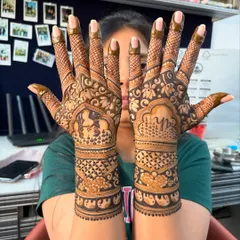 A stunning design for an engagement bride. This mehendi features a figure, initials, and a mix of floral and geometric patterns that extend up the arm.