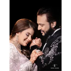 A gentle, romantic moment between the couple, highlighting the bride's intricate henna and the groom's adoring glance during their sangeet.
