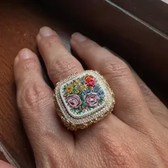 This statement ring captures a small, wild garden in micromosaic. Each tiny piece is hand-set to create a bouquet of roses, framed by an intricate 18k gold setting and a delicate diamond halo.