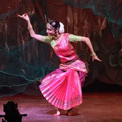 Performing a solo piece within the "UNMASKED" production. The stage design, featuring fishing nets, and the vibrant pink costume help create the world of ancient Lanka.