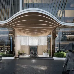 The grand entrance of the commercial tower in Pune. The flowing, parametric canopy with integrated lighting creates a dramatic and welcoming arrival experience.