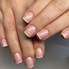 A beautiful example of a classic French manicure on short, natural square-shaped nails for a clean and professional look.